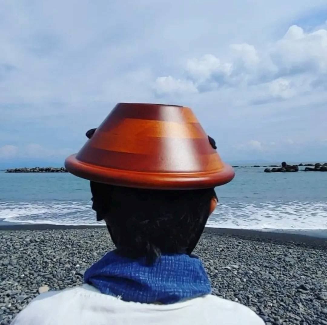静岡市内の海岸での百会セラピー。頭にオリジナルのハーブボールをのせたお客様